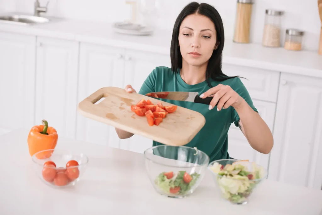 Woman in wheelchair cutting up vegetables