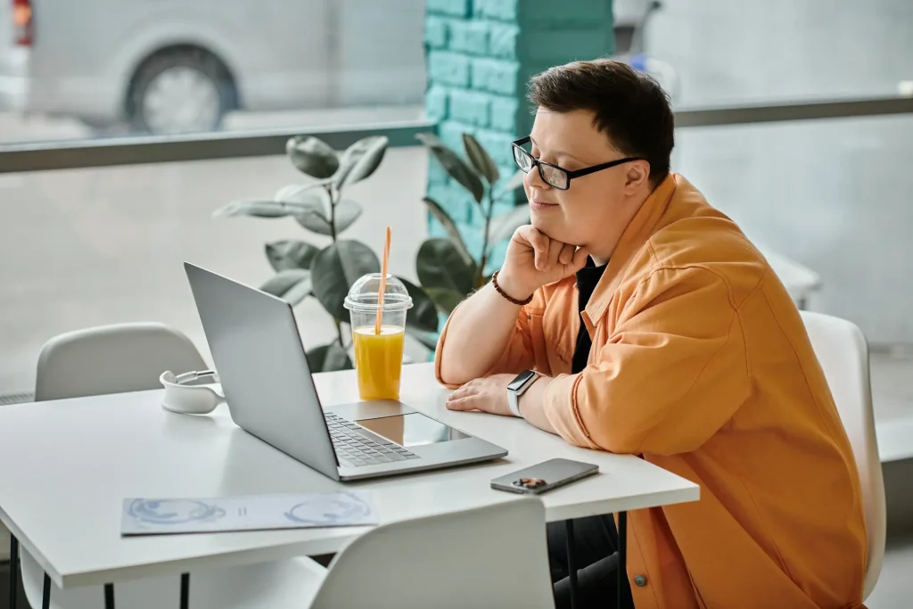 Disabled man in a cafe using computer to make a referral